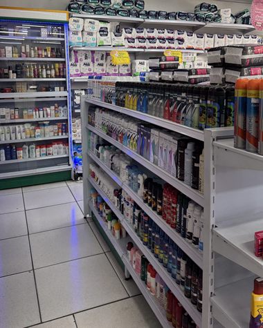 Corredor de higiene com desodorantes e produtos de banho, e uma vitrine refrigerada ao fundo.